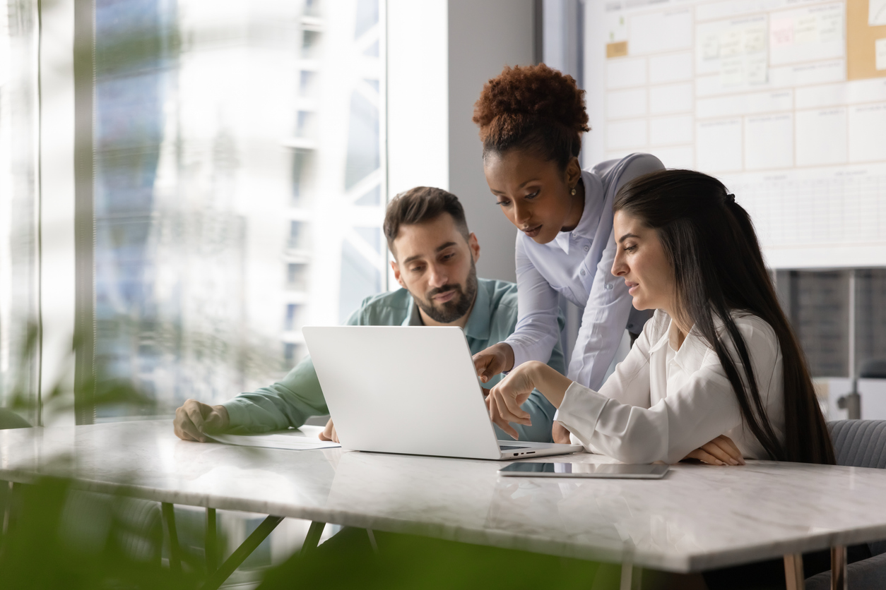 Employees working together around a computer